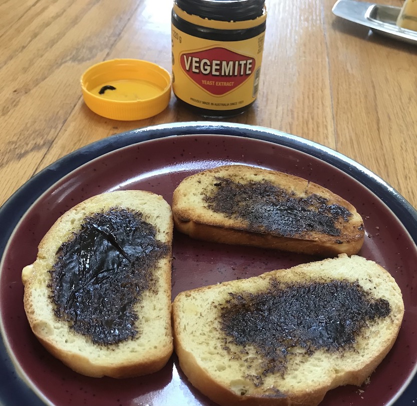 Toast on a plate, smeared with vegemite