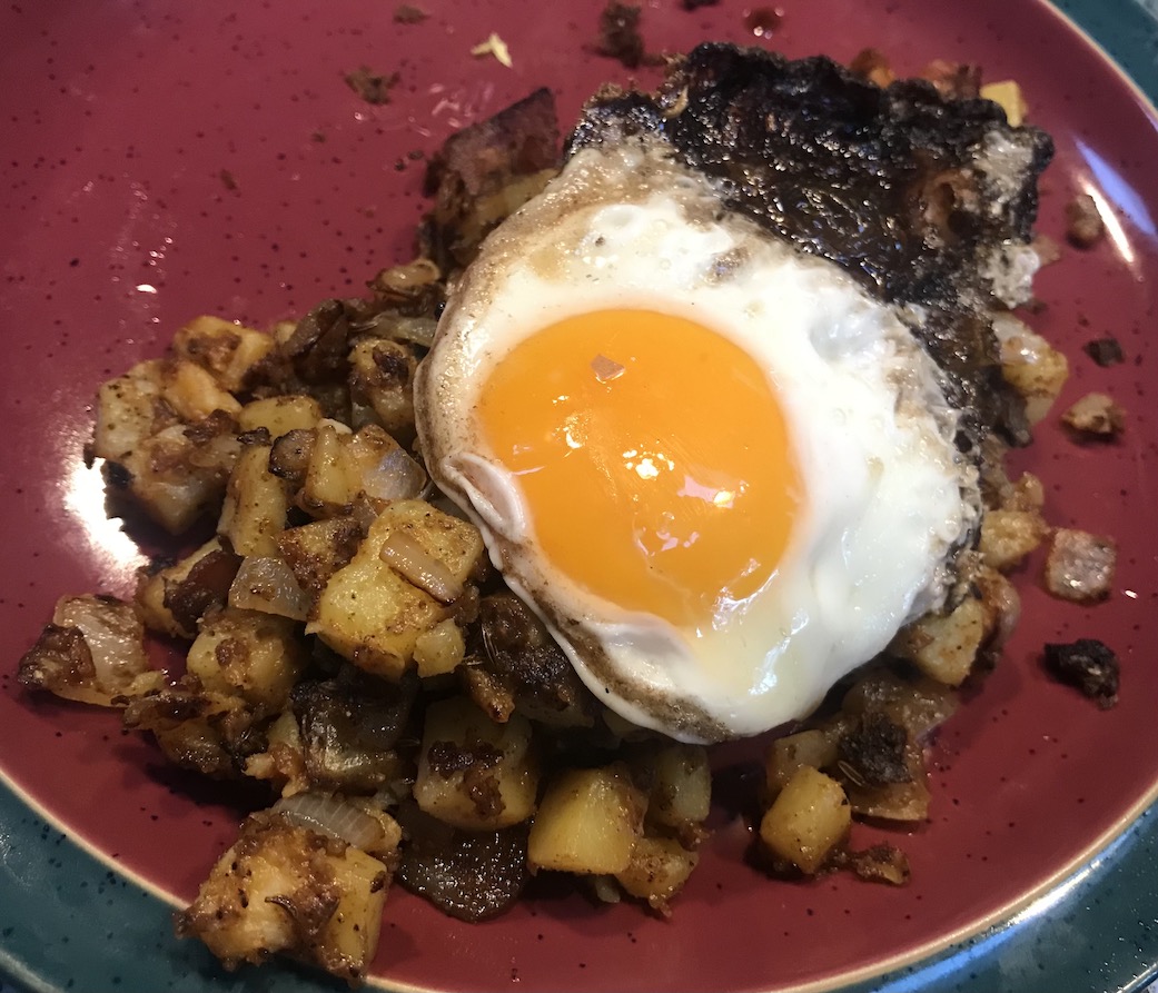 Fried egg on top of fried potatoes